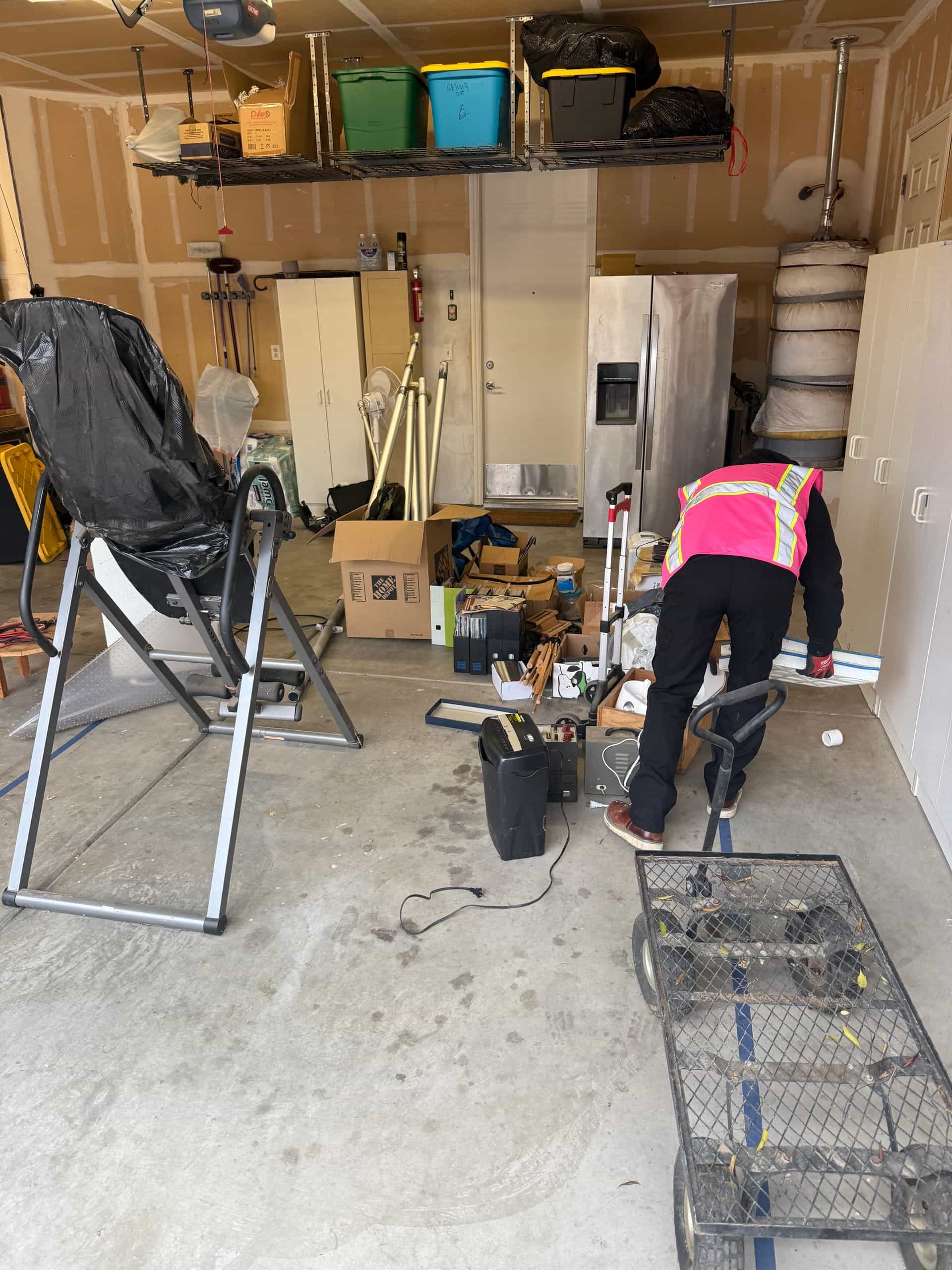 Papi's crew member in a pink vest clearing a garage — the kind of garage cleanout Papi's does in Fowler