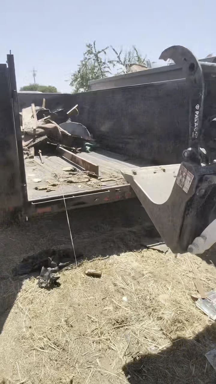 Papi’s crew member running a mini track loader to clear a backyard full of debris