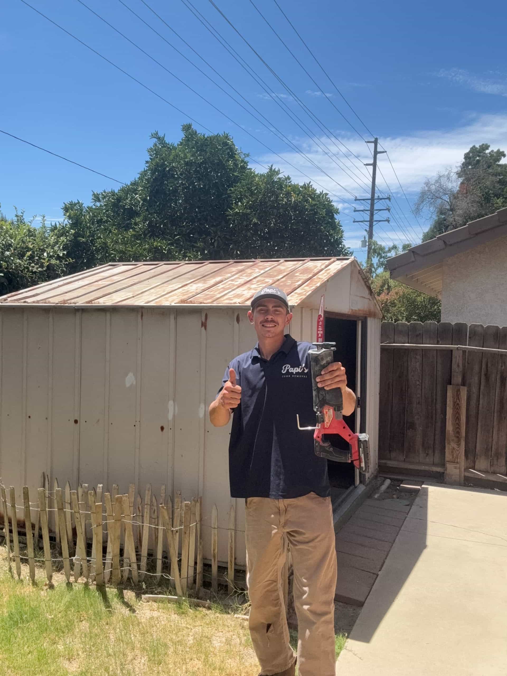 Papi's crew member before tearing down a metal shed near Visalia — yes, they make the drive
