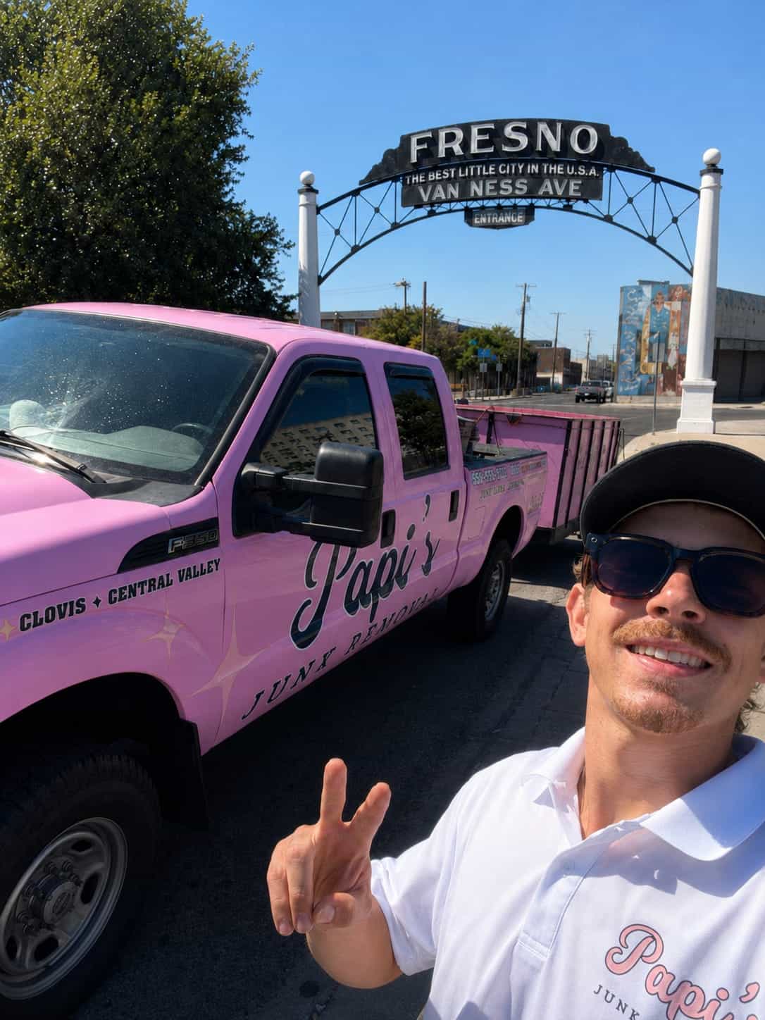 Papi's crew member and the pink Papi's F-250 under the Fresno Van Ness Avenue arch