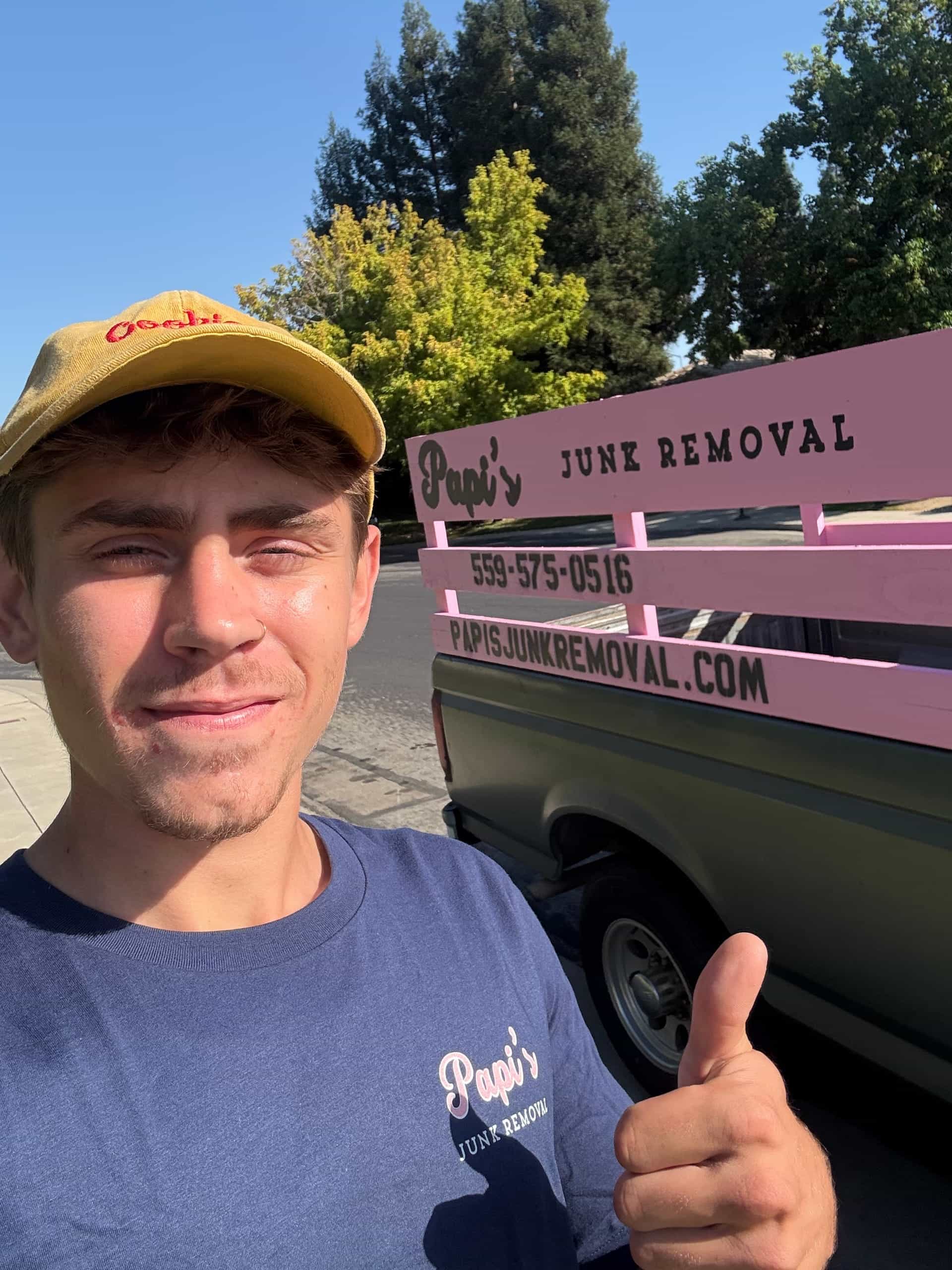 Papi's crew member in a yellow Papi's cap giving a thumbs-up after a Central Valley job