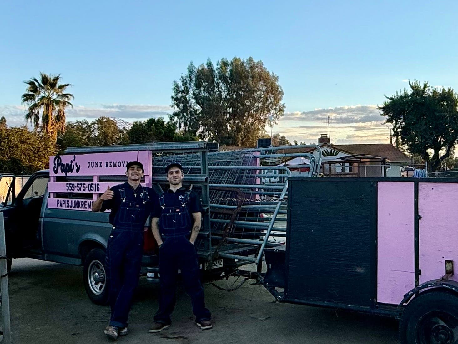 Two Papi's crew members with the pink-rack truck and trailer at a ranch gate