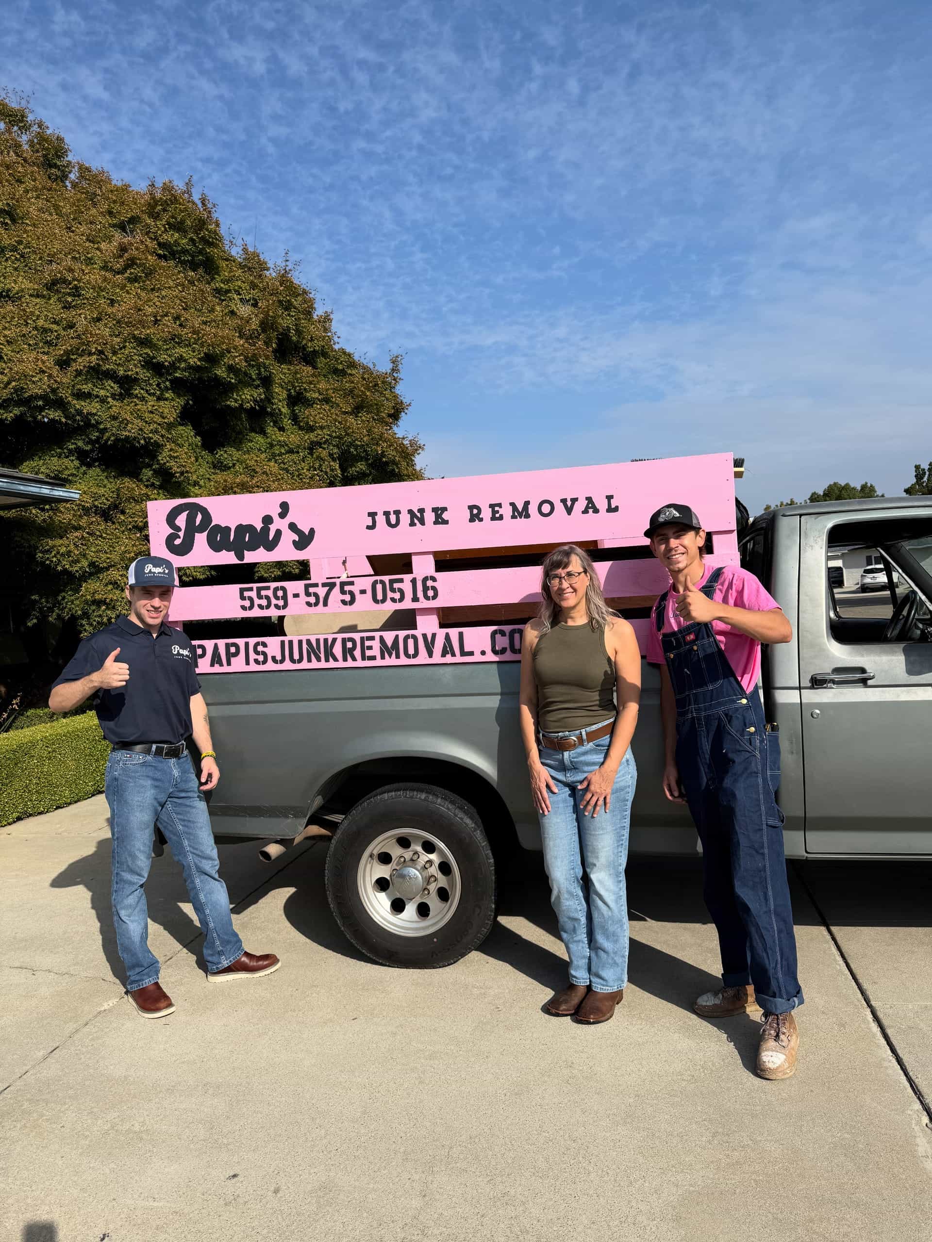 Papi's crew member with two customers beside the pink-rack Ford pickup in a Central Valley driveway