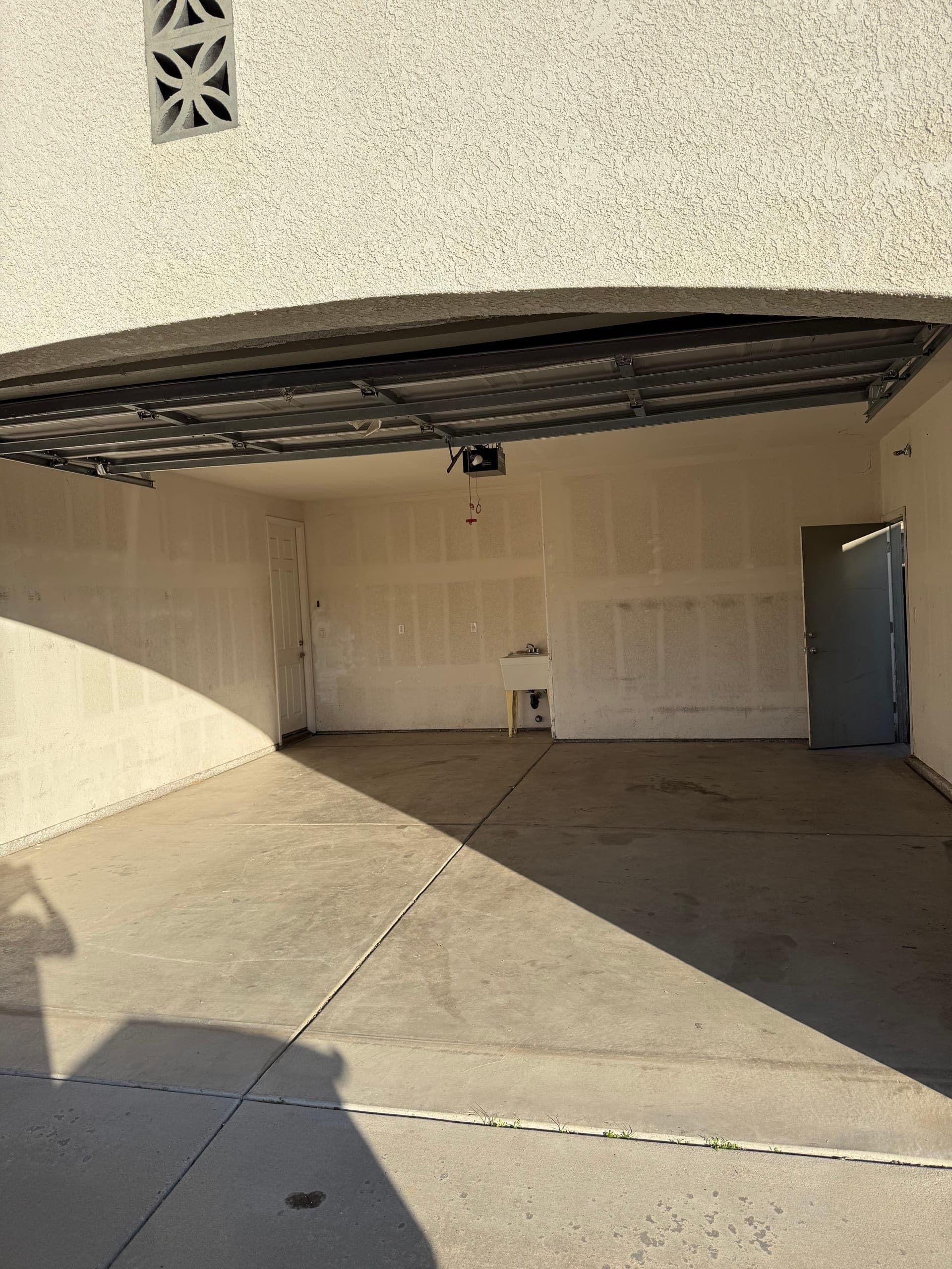 The same garage after Papi's cleared it, empty to the back wall and utility sink