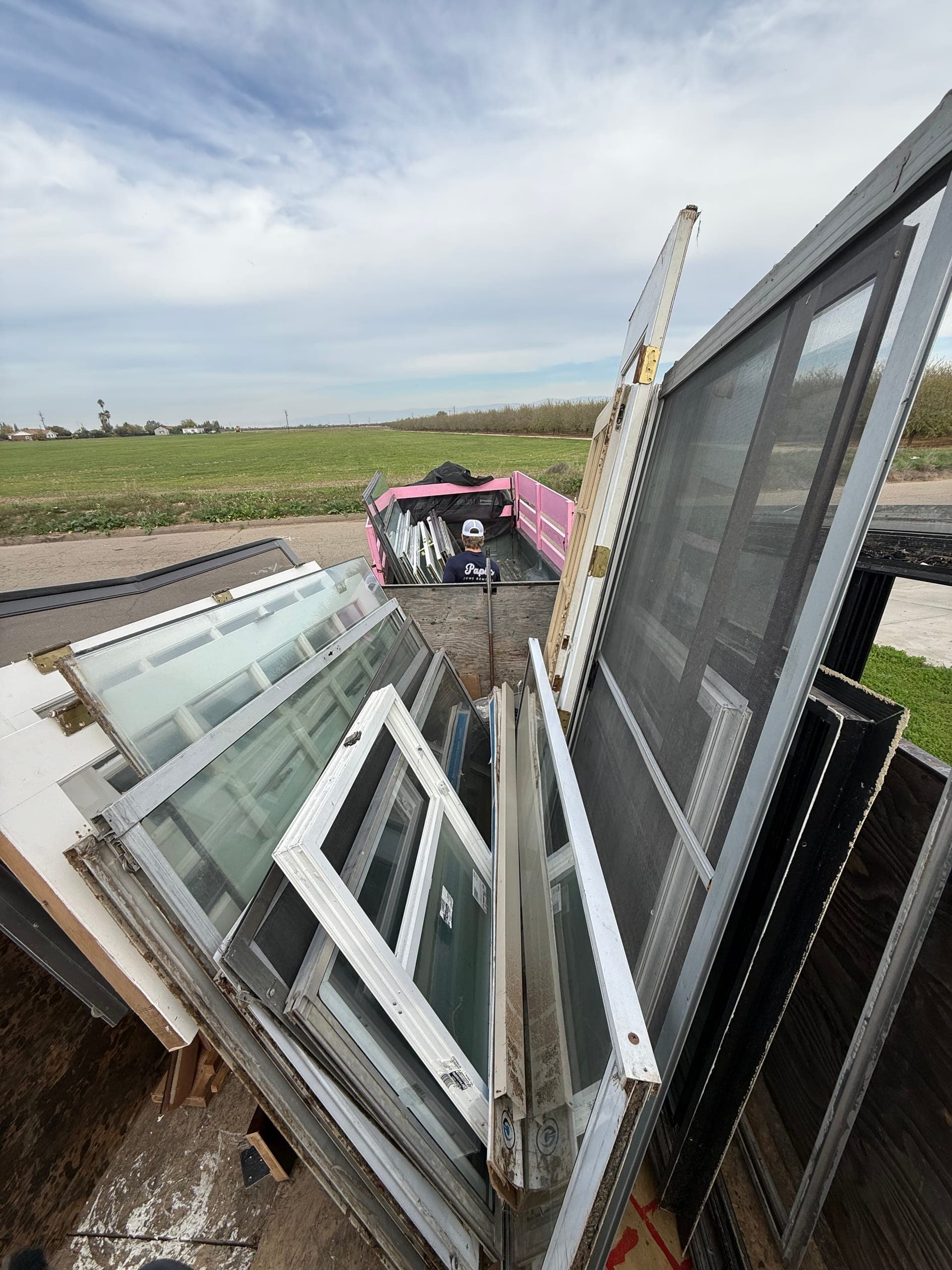 Stack of old windows and sliding doors loaded for haul-away in the Central Valley