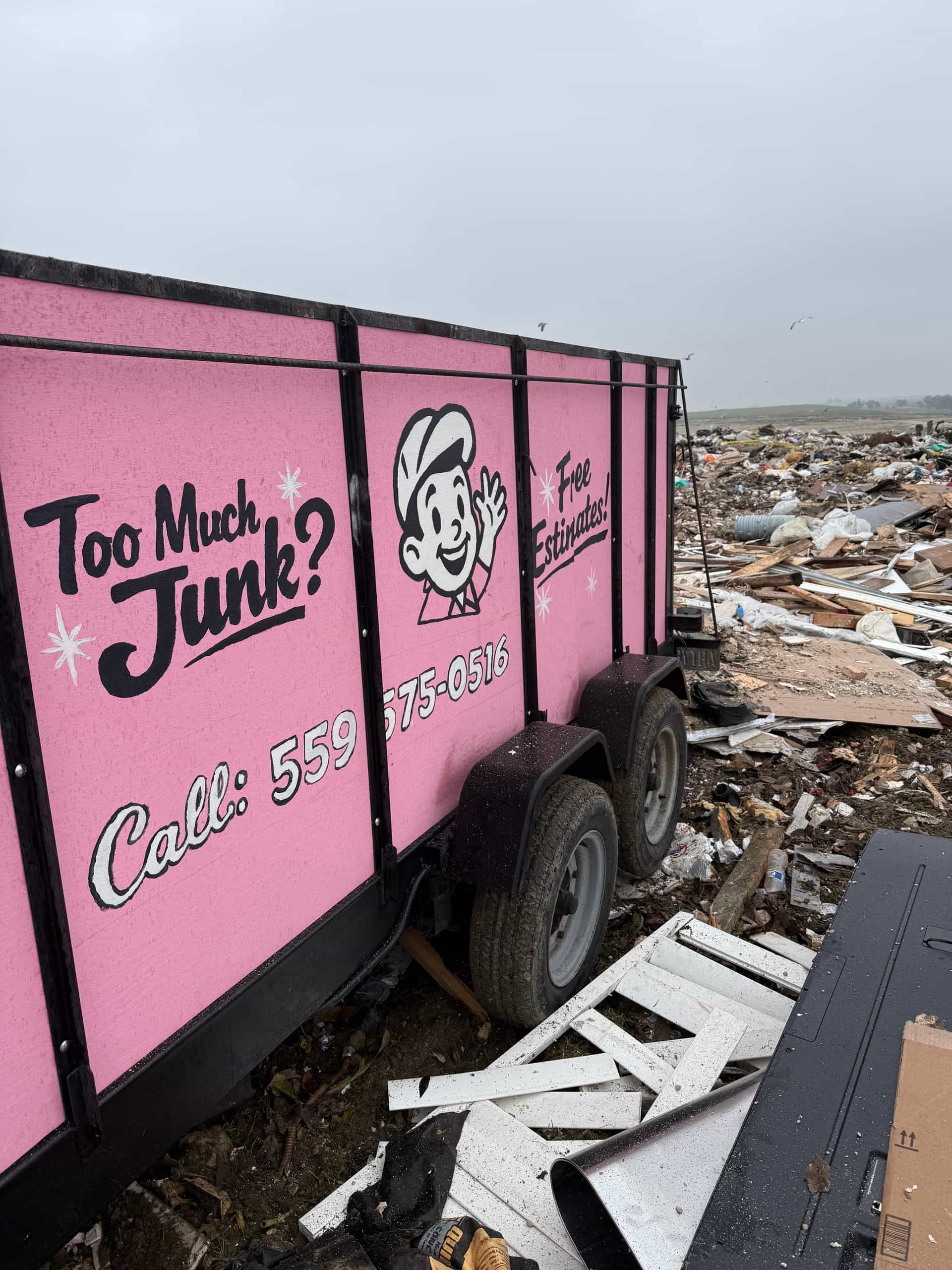 Papi's pink 'Too Much Junk?' trailer unloading at a transfer station