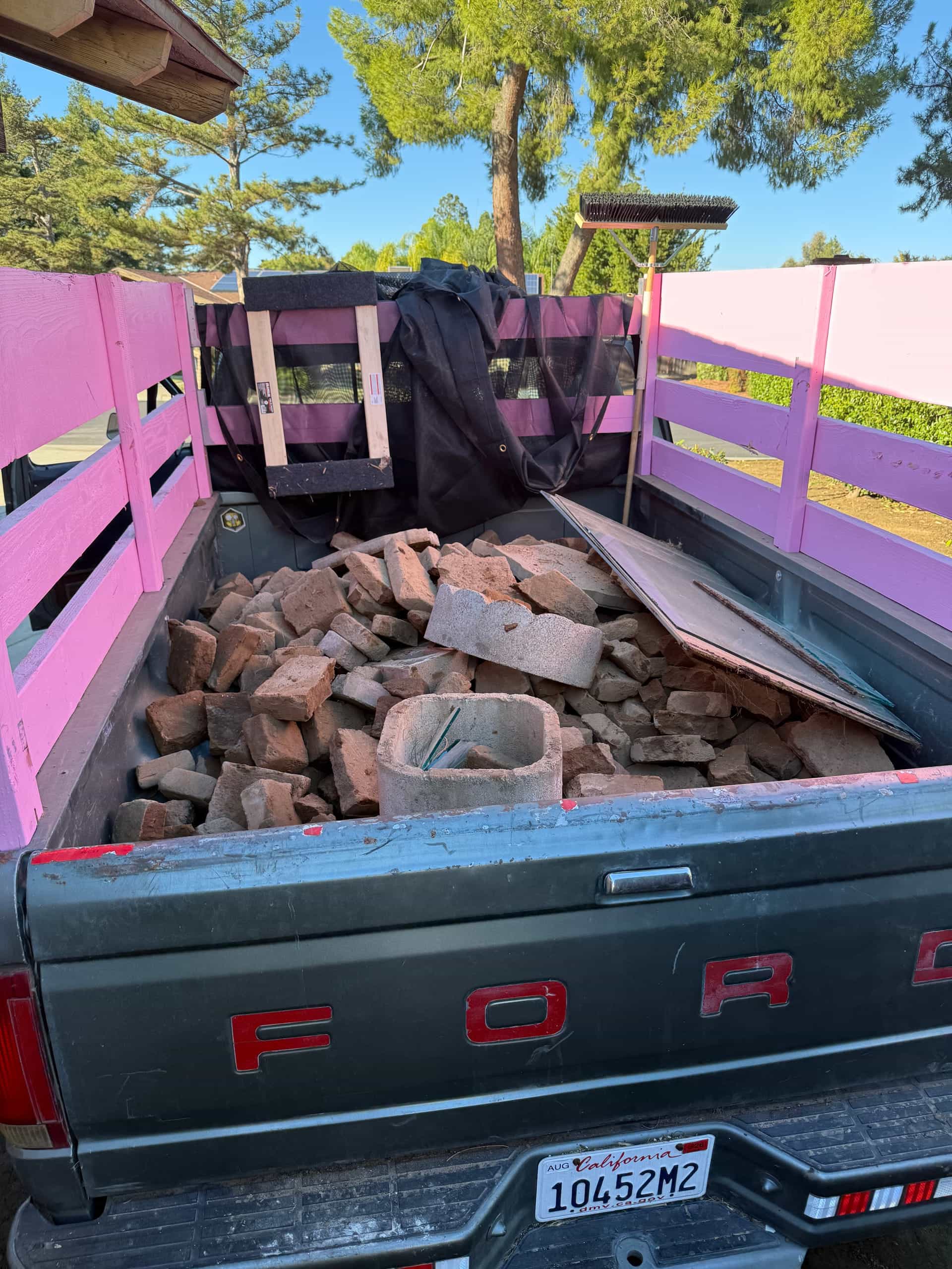Truck bed full of old red bricks hauled by Papi's Junk Removal