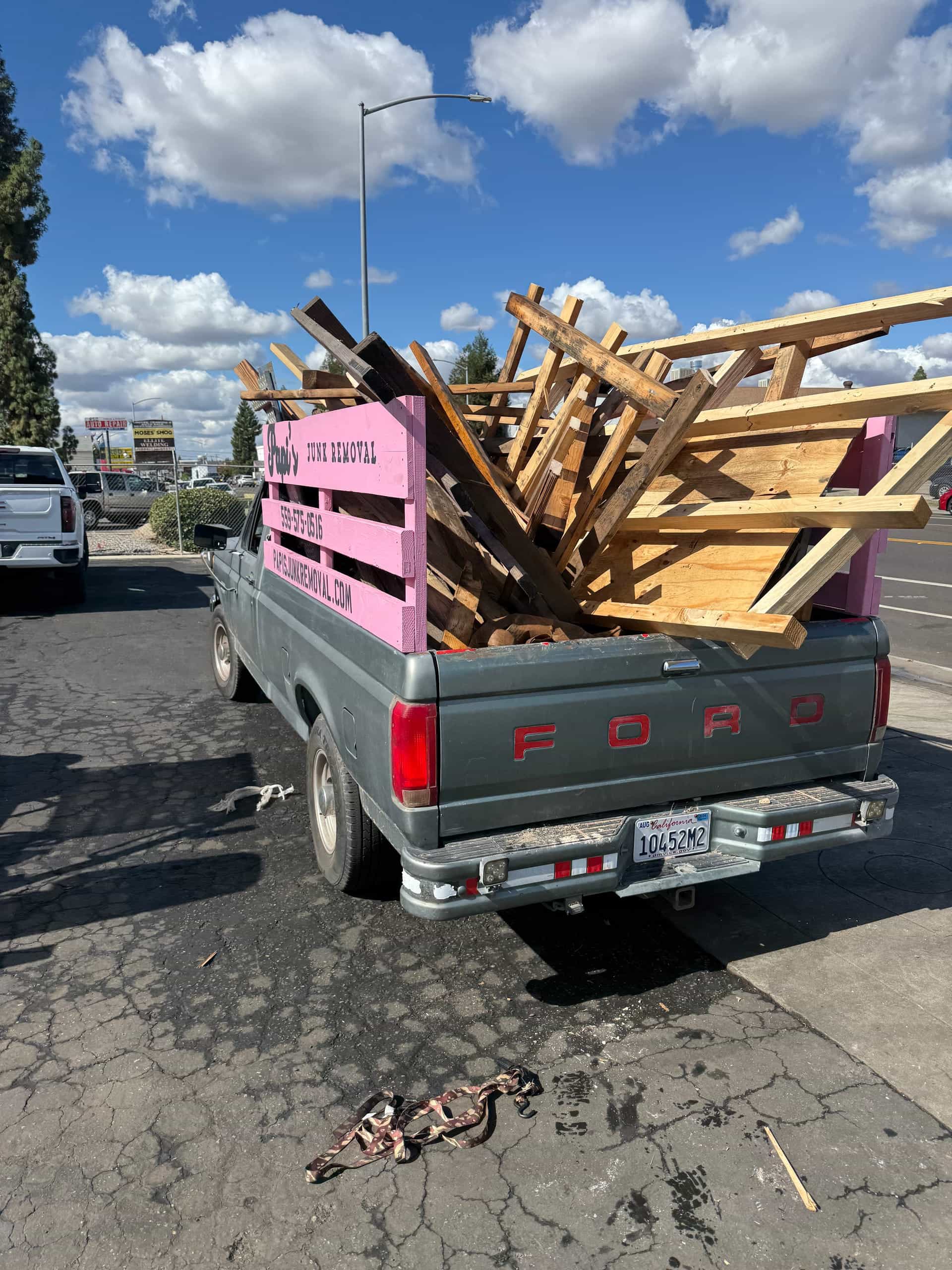 Papi's pink-rack truck piled high with lumber and broken pallets