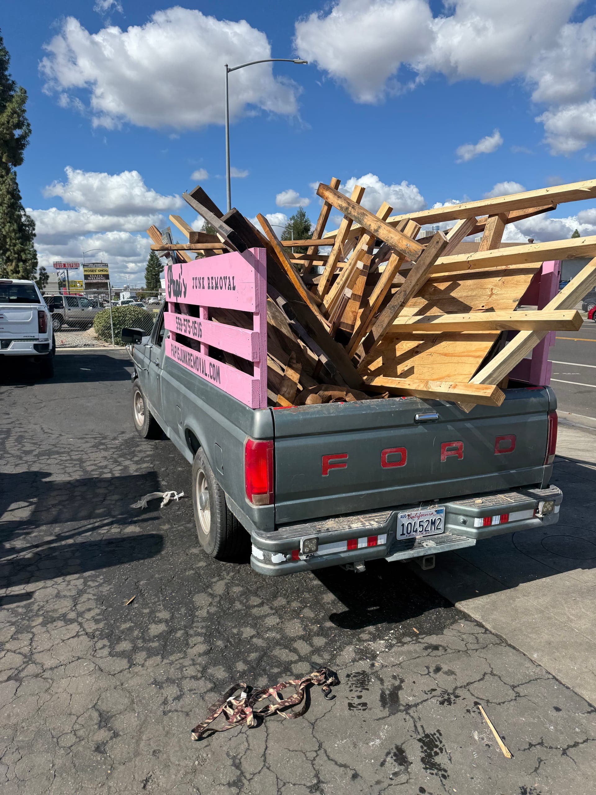 Papi's pink-rack truck piled high with lumber and broken pallets