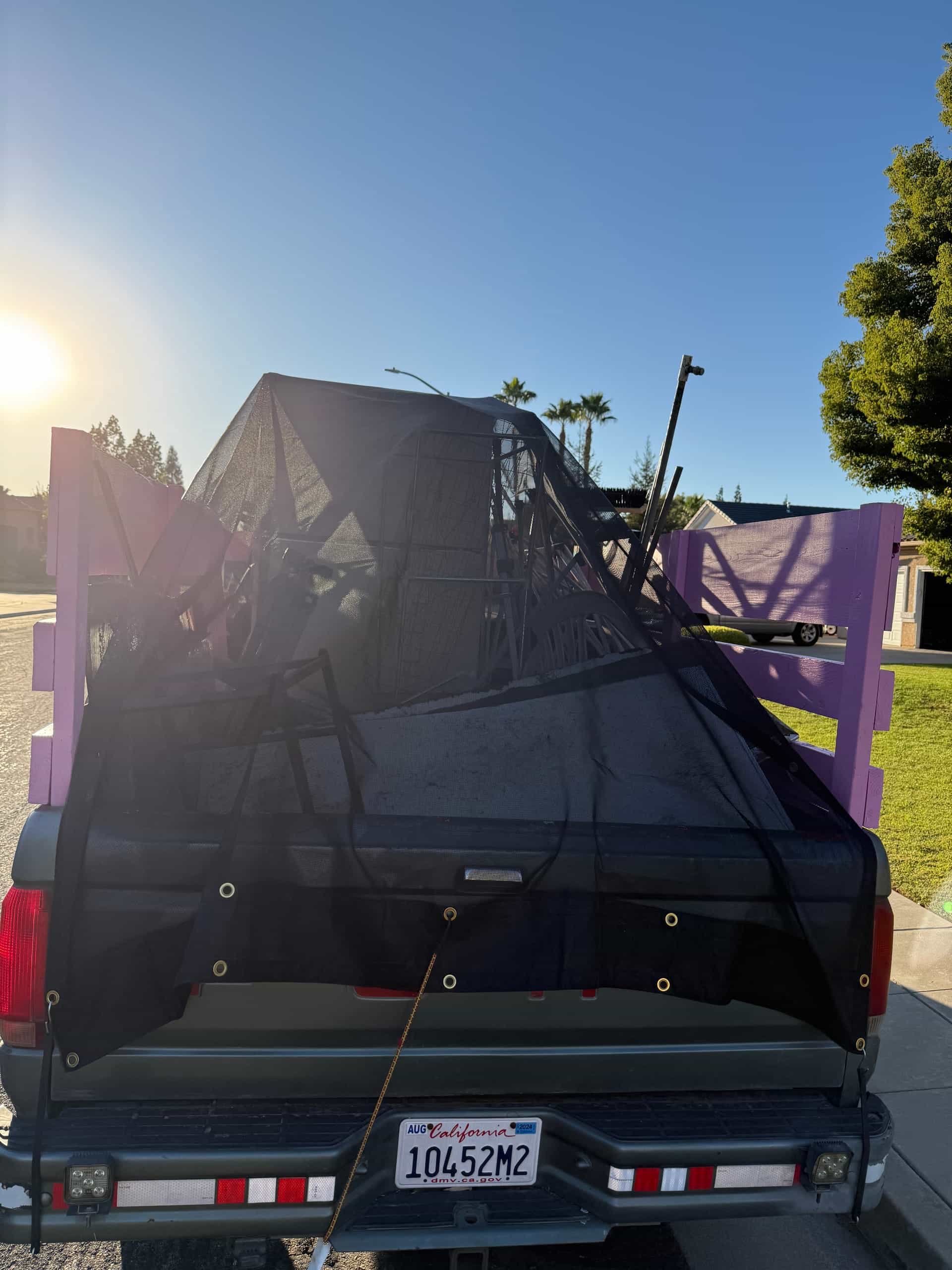 Full Papi's truck load tied down under a cargo net, ready to leave the job