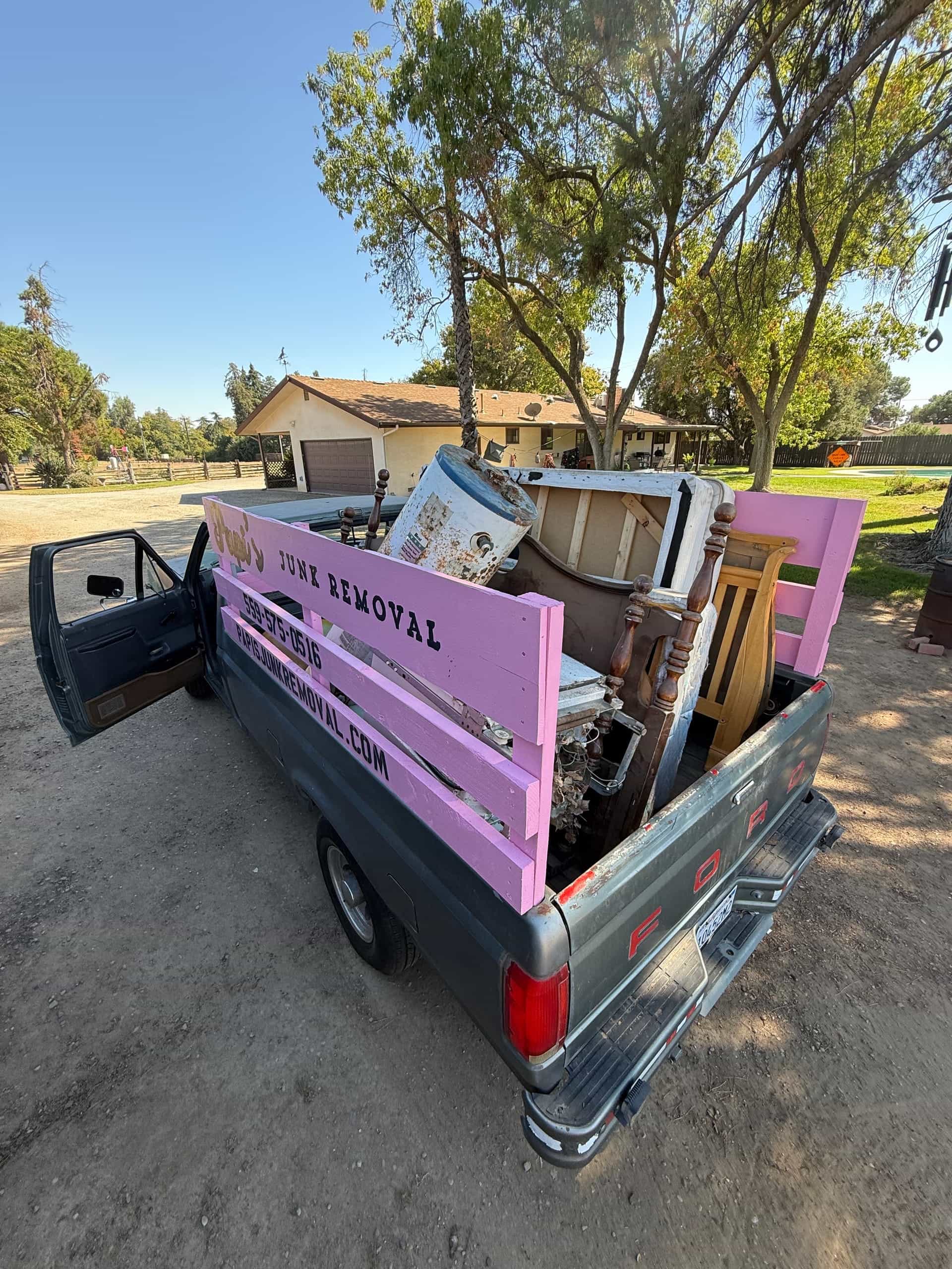 Papi's truck loaded with appliances and furniture behind a Central Valley ranch house