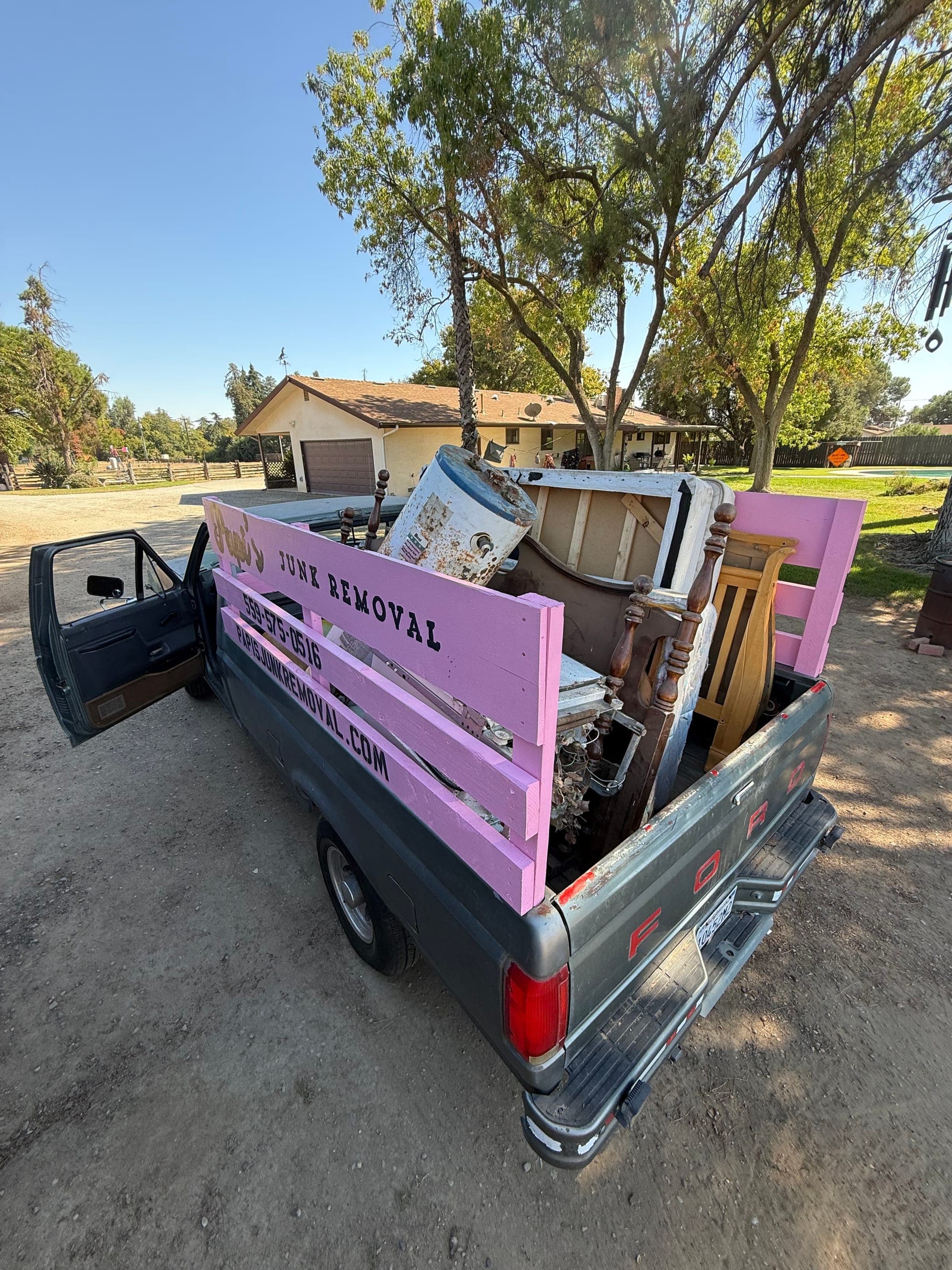 Papi's truck loaded with appliances and furniture behind a Central Valley ranch house